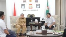 Wali Kota Makassar, Munafri Arifuddin (kiri, berseragam dinas), berdiskusi bersama Kepala BPJS Ketenagakerjaan Cabang Makassar, I Nyoman Hary Sujana (kanan), dalam audiensi terkait perluasan kepesertaan Jaminan Sosial Ketenagakerjaan di Balai Kota Makassar, Senin (16/6/2025).