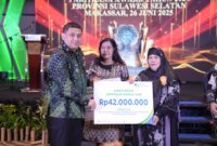 Wali Kota Makassar, Munafri Arifuddin, menyerahkan santunan jaminan kematian sebesar Rp42 juta kepada ahli waris peserta BPJS Ketenagakerjaan pada acara Paritrana Award Provinsi Sulawesi Selatan di Makassar, 26 Juni 2025.