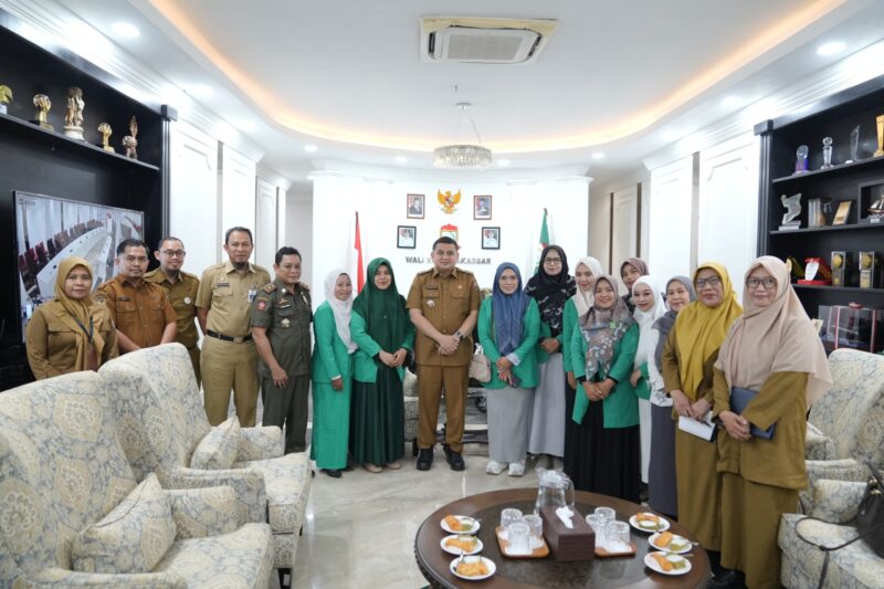 Wali Kota Makassar, Munafri Arifuddin, berfoto bersama jajaran pemerintah kota dan perwakilan organisasi perempuan usai audiensi di Balai Kota Makassar, Selasa (8/7/2025).