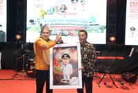Foto: Walikota Makassar Munafri Arifuddin saat menerima karikatur yang diberikan langsung oleh Camat Biringkanaya