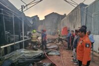 Petugas BPBD dan Damkar Kota Makassar melakukan pemadaman serta asesmen di lokasi kebakaran rumah usaha di Jalan Perintis Kemerdekaan VII, Tamalanrea, Minggu (31/8/2025).