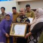 Foto: Kepala Dinas Komunikasi dan Informatika Kota Makassar, Dr. M. Roem saat menerima penghargaan Keterbukaan Informasi Publik
