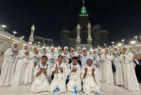 Jamaah umrah ZZ Travel berdoa bersama di pelataran Masjidil Haram, Makkah, dengan latar Menara Abraj Al Bait, mencerminkan kekhusyukan dan kebersamaan dalam ibadah.