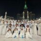 Jamaah umrah ZZ Travel berdoa bersama di pelataran Masjidil Haram, Makkah, dengan latar Menara Abraj Al Bait, mencerminkan kekhusyukan dan kebersamaan dalam ibadah.